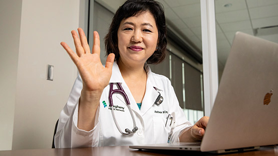 AHN Saint Vincent Doctor sitting at a laptop for a virtual appointment.